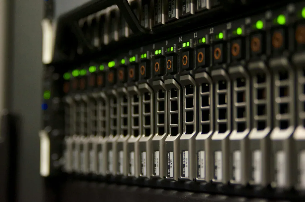 Serverschrank mit grün blinkenden Netzwerk-Kabeln, Symbolbild für Infrastruktur-Sicherheit