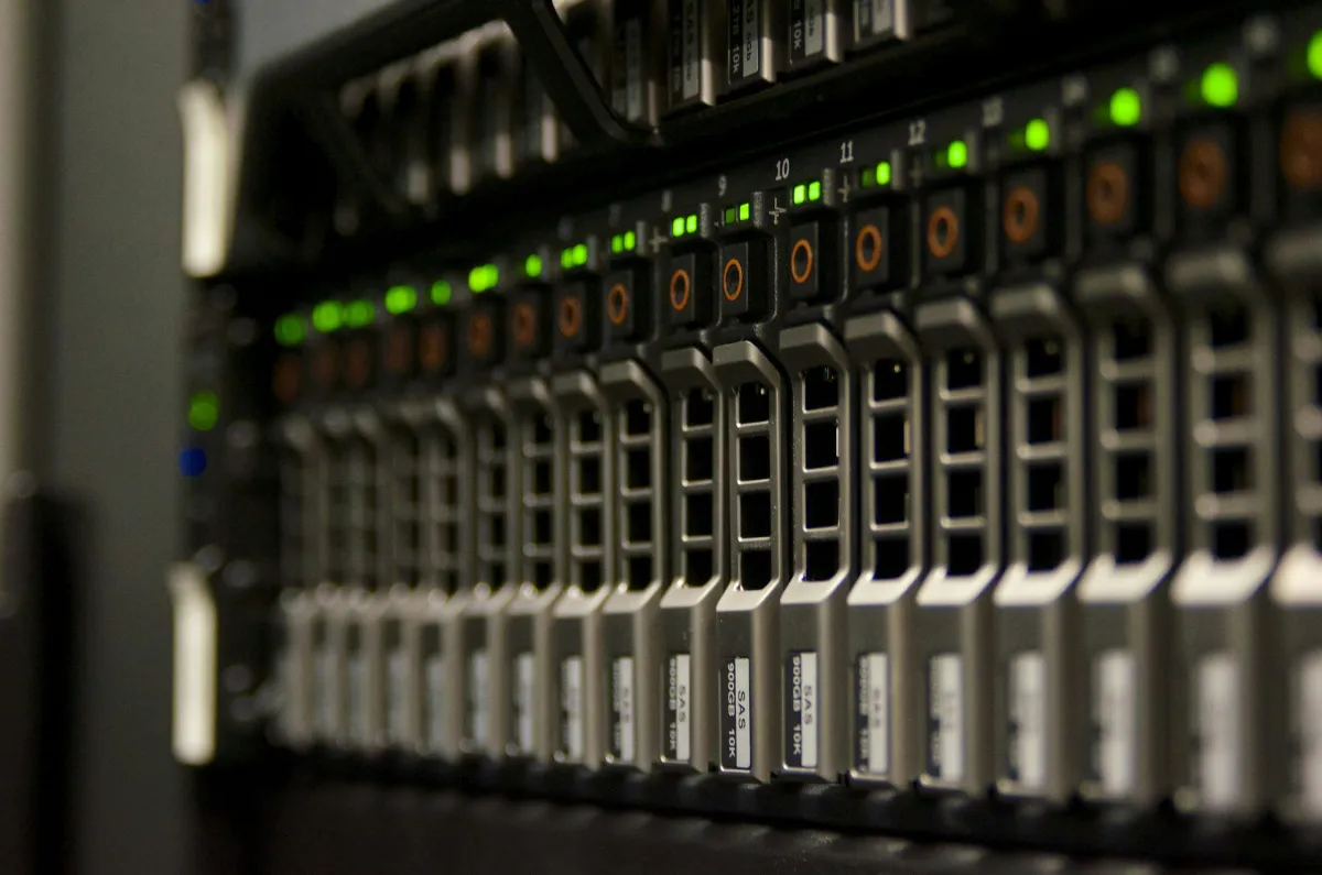 Serverschrank mit grün blinkenden Netzwerk-Kabeln, Symbolbild für Infrastruktur-Sicherheit